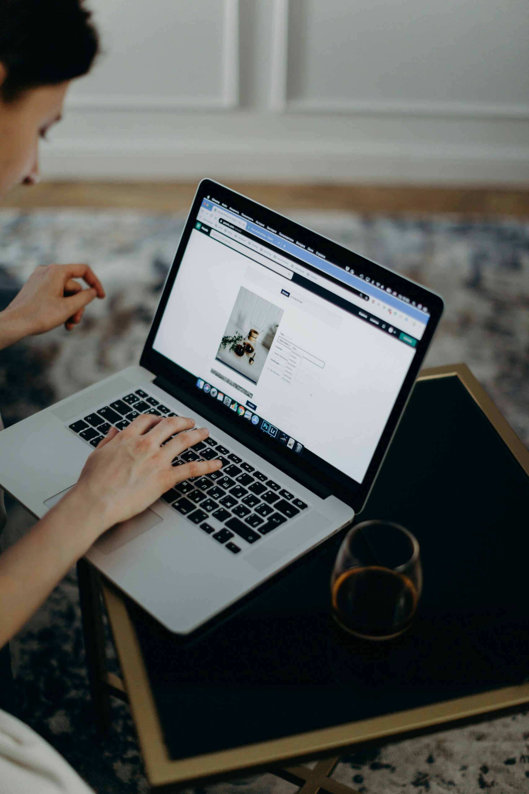 Close-up of a person working remotely on a laptop indoors. Ideal for remote work or technology themes.
